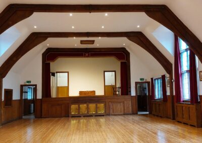 Stage View – resurfaced floor gleaming beneath the red‑curtained stage